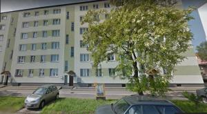 two cars parked in front of a large building at Grey Apartament Centrum Gdynia in Gdynia