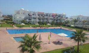 una grande piscina di fronte a un grande edificio di magnifique appartement Saidia a Saïdia
