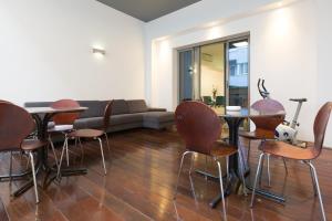 a living room with a couch and tables and chairs at Apartments City Wellness Center in Zagreb
