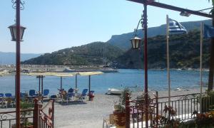 a beach with chairs and umbrellas and a body of water at Porto Sabatiki in Sampatiki