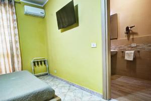 a small room with a bed and a tv on the wall at Kosmos in Siracusa