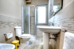 La salle de bains est pourvue de toilettes et d'un lavabo. dans l'établissement Kosmos, à Syracuse