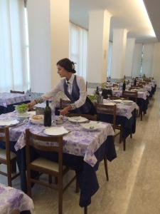 Una donna seduta a un tavolo in una sala da pranzo di Hotel Euromar a Rimini
