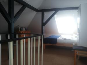 ボルクムにあるStrandvilla zum Erholenのベッドルーム1室(ベッド1台付)、階段(窓付)が備わります。