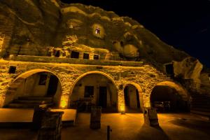an old stone building with a stone wall at night at Elite Cave Suites in Göreme