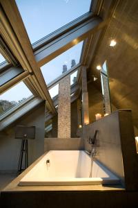 a bath tub in a bathroom with a large window at Suite & B by Hofke van Bazel in Bazel