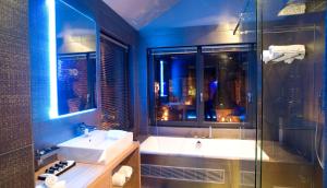 een badkamer met een bad, een wastafel en een douche bij Suite & B by Hofke van Bazel in Bazel