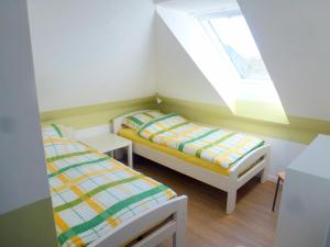 Duas camas num pequeno quarto com uma janela em Ferienwohnung Am Runenstein 7 em Busdorf