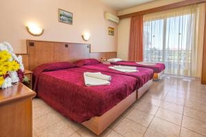 a hotel room with two beds with red sheets at Alea Hotel Apartments in Ialysos