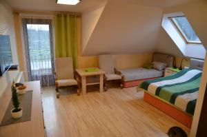 a bedroom with a bed and a couch and a table at Białowieski Raj in Białowieża