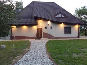 une maison blanche avec un toit noir et une allée. dans l'établissement Chillout-House, à Mińsk Mazowiecki