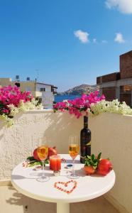 Apollonia Apartments في أغيا بيلاغيا: طاولة مع كأسين وزجاجة من النبيذ