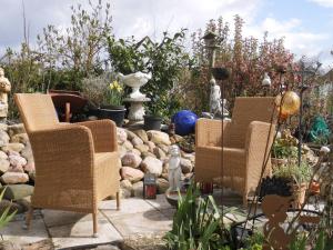 twee stoelen in een tuin met rotsen en planten bij Charmante Ferienwohnung in Plön