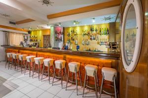 eine Bar mit einer Reihe von Hockern in einem Restaurant in der Unterkunft Alea Hotel Apartments in Ialyssos