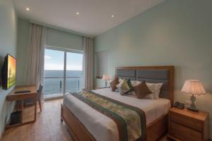 a bedroom with a bed with a view of the ocean at Ocean Edge Suites & Hotel Colombo in Colombo