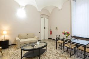 a living room with a couch and a table and chairs at Helvetia Suite in Genova +9 photos