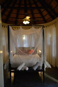 Bett mit Moskitonetz in einem Zimmer in der Unterkunft Kruger River Villas - Mtombo in Marloth Park