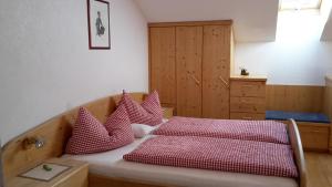 ThurnにあるMoarhofのベッドルーム1室(赤と白の枕が備わるベッド1台付)