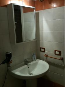 ファヴィニャーナにあるOrange House Favignanaのバスルーム(白い洗面台、鏡付)