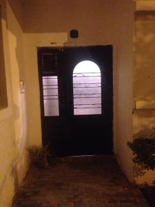 Cozy Appartement في Douar Ben Chellal: باب أسود مع نافذة في مبنى