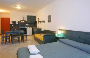 a living room with two beds and a kitchen at Residence Borgo San Sebastiano in Bergeggi