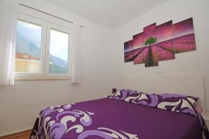 a bedroom with a purple bed and a window at Apartment Ivana in Makarska