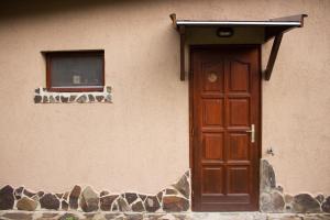 un edificio con una puerta de madera y una ventana en Börzsöny Vendégház en Nagymaros