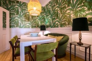 uma sala de jantar com uma mesa e cadeiras verdes em Portas De São Bento Apartments em Lisboa