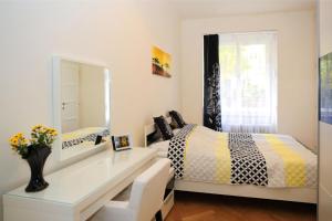 a bedroom with a bed and a desk with a mirror at Yellow apartment few steps from metro in Prague