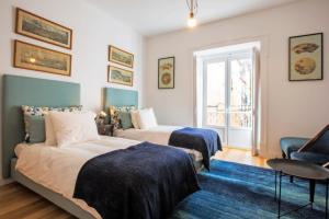 a bedroom with two beds and a blue rug at Portas De São Bento Apartments in Lisbon