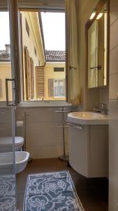 bagno con lavandino, servizi igienici e finestra di Heart of Parma a Parma