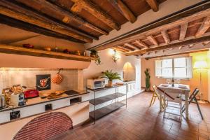 ein Wohnzimmer mit einem Tisch und einer Küche in der Unterkunft Micheli Suite Anfiteatro Square in Lucca