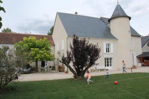 zwei Kinder spielen mit einem Ball im Hof eines Hauses in der Unterkunft Manoir le Bout du Pont in Huisseau-sur-Cosson