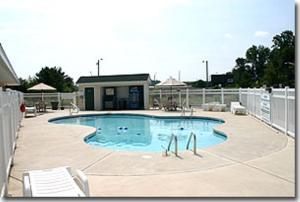 una gran piscina con 2 sillas y un edificio en Sea Esta Motel II, en Long Neck