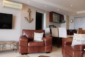 sala de estar con sofá y silla en Seafront Apartment in Mossel Bay, en Mossel Bay