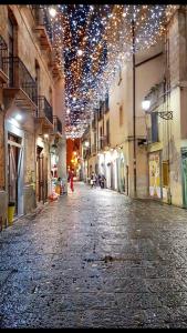 une rue vide avec des lumières de Noël suspendues à des bâtiments dans l'établissement B&B Luxury Salerno Central, à Salerne