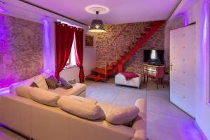 a living room with a couch and a staircase at Le Rendez Vous de Vauban Gites & Spa in Mont-Dauphin