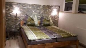 ein Schlafzimmer mit einem Bett und einer Ziegelwand in der Unterkunft Greenheart Aussee in Obersdorf