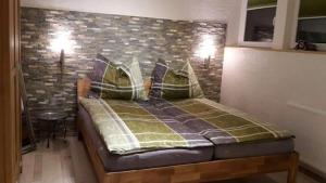 sypialnia z łóżkiem i ścianą z cegły w obiekcie Greenheart Aussee w mieście Obersdorf