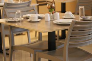 a wooden table with plates and dishes on it at Bridgeville Guest House( Pty) Ltd in Gaborone