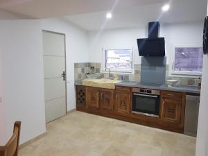 a kitchen with a sink and a stove top oven at Le Perron in Lézigneux
