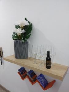 una estantería de madera con copas y una botella de vino en ML Apartments Aliados, en Oporto