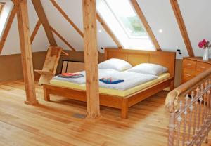 ein Holzbett in einem Zimmer mit Fenster in der Unterkunft Ferienwohnungen im Gutshaus Gnies in Gnies