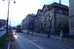 uma rua com um edifício e um carro dirigindo por uma rua em Apartament Aga em Cracóvia