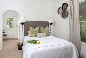 Un dormitorio con una cama blanca con una flor amarilla. en An Inn to Remember, en Sonoma