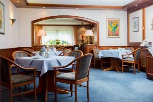 a dining room with tables and chairs and a mirror at Hotel Sonnenhof in Bad Sachsa