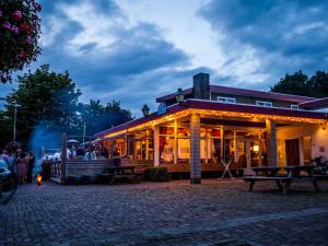 a building with people standing outside of it at night at Hotel and Restaurant van Saaze - Free Parking in Kraggenburg