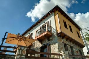 a house with an umbrella in front of it at Elaion Terra Boutique Guesthouse in Theologos