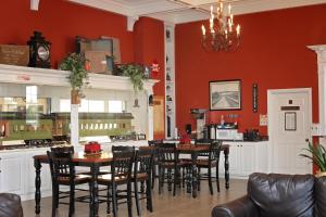 a dining room with red walls and tables and chairs at Depot Inn & Suites in La Plata