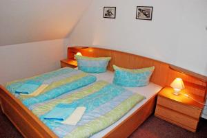 バーベにあるFerienapp Dr Beate Gurle Und Drの青い枕が備わる小さな部屋のベッド2台